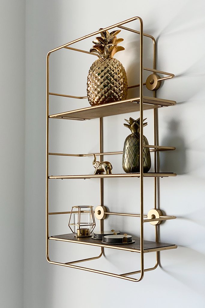 Goldenes Wandregal, goldene Accessoires im Innenraum, moderner Stil