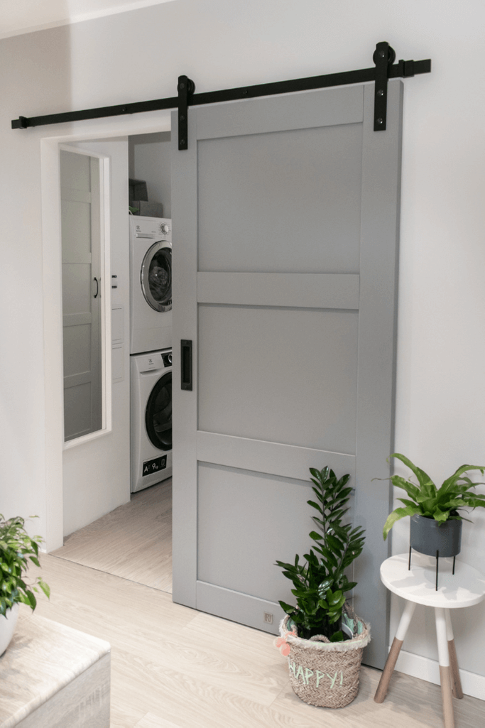 Schiebetür im Wohnblock, Holzschiebetür, Schiebetür zur Speisekammer, graue Schiebetür, Schiebetür zum Hauswirtschaftsraum, Blumen in der Halle, Schiebetür in der Halle