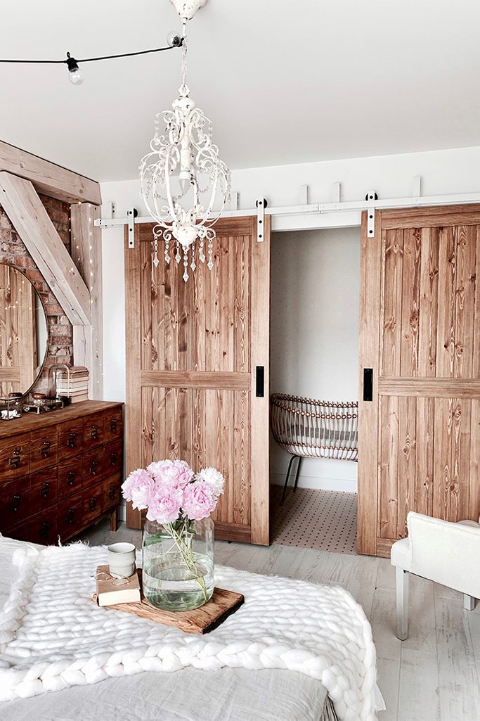 Rustikal Schlafzimmer, Holzschiebetür, Schiebetür, rustikaler Stil im Innenraum, moderner rustikaler Stil, Scheunen-Schiebetüren, weiße Schiebesystem, Bypass Schiebetüren, Bypass Wandhalterung für Schiebetüren, weiße rustikale Kronleuchter, Ziegel an der Schlafzimmerwand