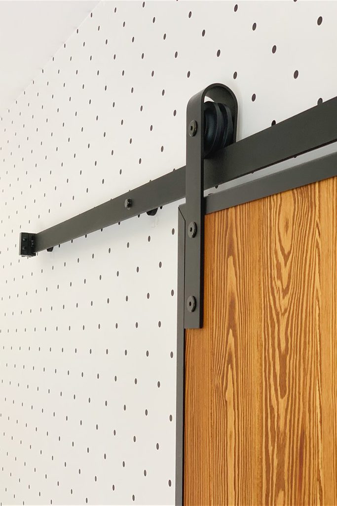 Schiebetürsystem, Schiebetür Aufhänger, Schiebetür Führungsschiene, Loft-Tür, Holztür in einem Metallrahmen, Schiebetür aus Holz und Stahl, Tür aus Kiefern, gepunktete Tapete
