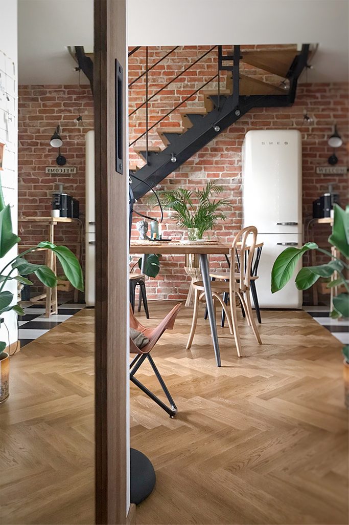 Loft-Interieur, Vintage-Möbel, Loft-Treppen, Ziegel an der Wand im Wohnzimmer, Vintage-Kühlschrank, Retro-Accessoires für die Wohnung, Industrielampen, Parkett im Wohnzimmer