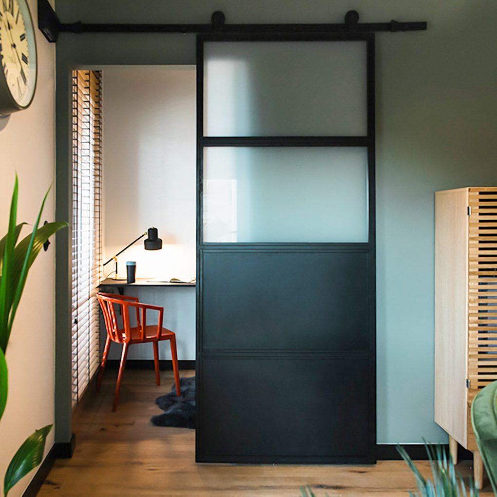 Industrielle Schiebetüren, Metall- und Glas Türen, mit Milchglas gefüllte Türen, Schiebetüren zum Schlafzimmer, kleine Arbeitsecke, roter Stuhl