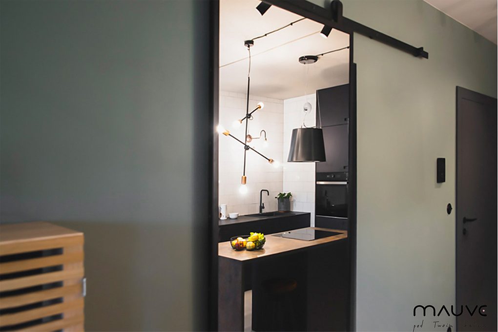 großer Spiegel in einem Metallrahmen, industrielle Pendelleuchten, Metalllampen für die Küche, schwarze Metalllampen über der Insel in der Küche