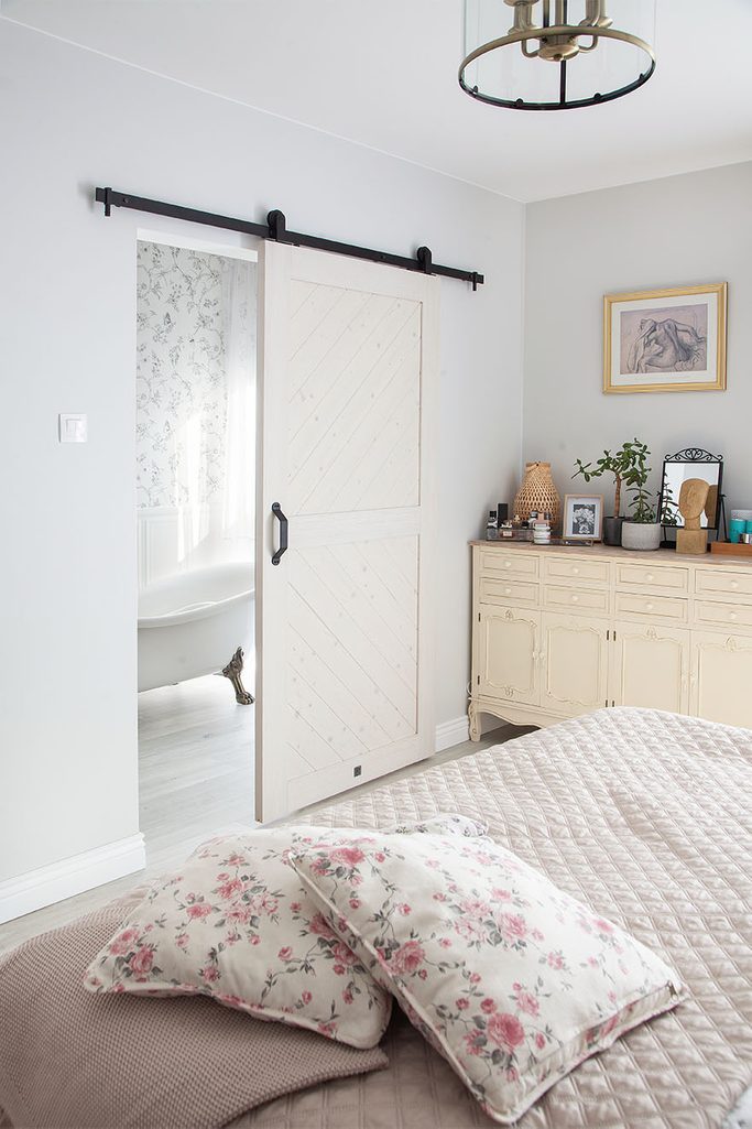 Badezimmer neben dem Schlafzimmer durch eine weiße Schiebetür getrennt