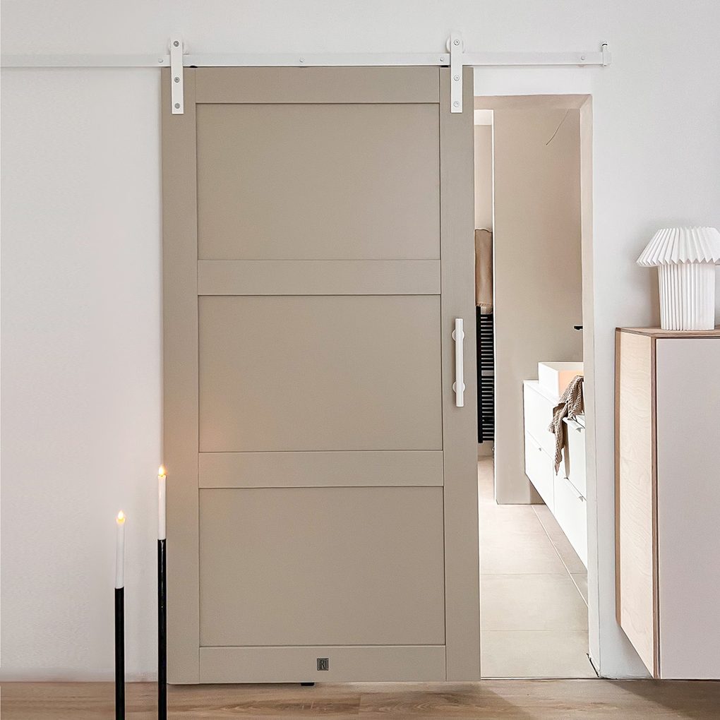 kieselgraue Tür an einem weißen Schiebesystem im Eingang zum Badezimmer